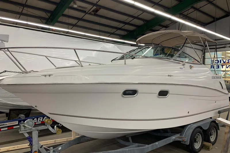 Slide: The Image of 2003 Four Winns 248 Vista boat on trailer in indoor storage facility. - 2