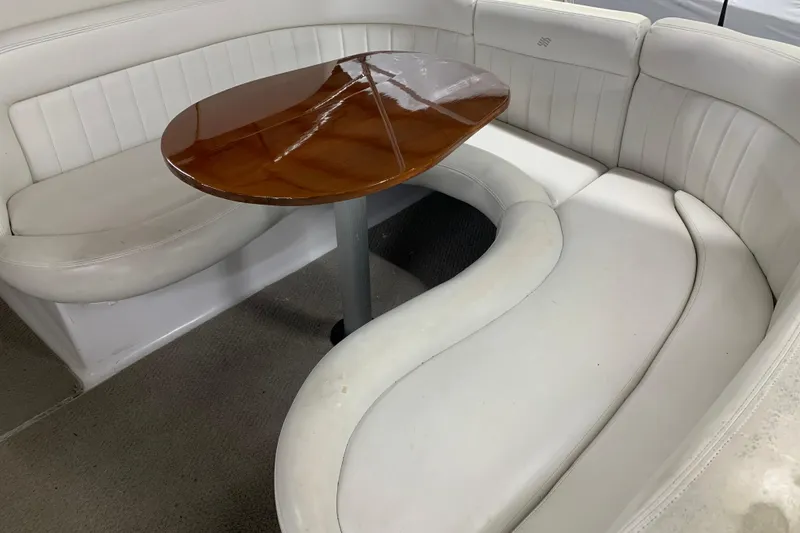 Slide: The Image of 2003 Four Winns 248 Vista boat interior with white seating and wooden table. - 9