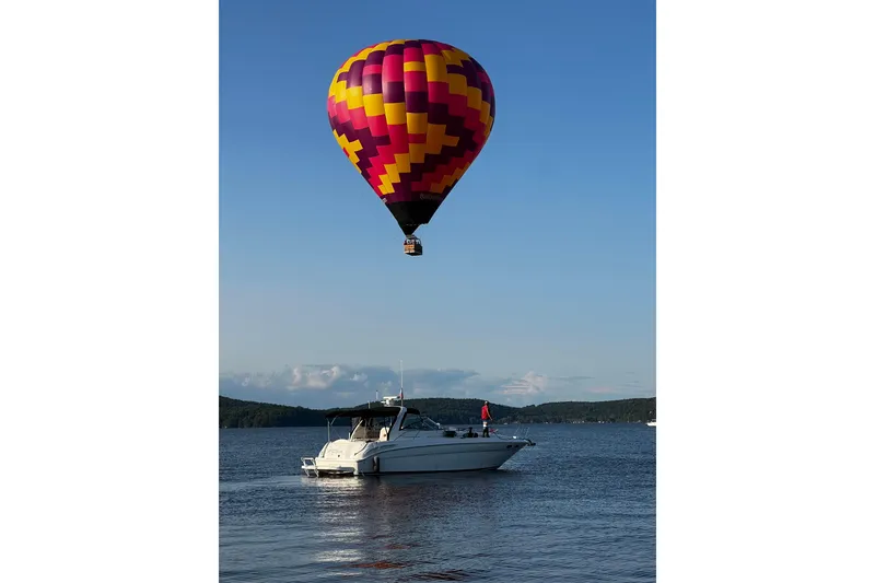The Image of Hot air balloon over 2001 Sea Ray 380 Sundancer on a serene lake. - 0