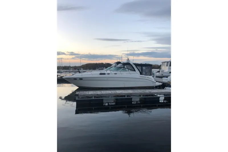 Slide: The Image of 2001 Sea Ray 380 Sundancer yacht docked at sunset, reflecting on calm water. - 1
