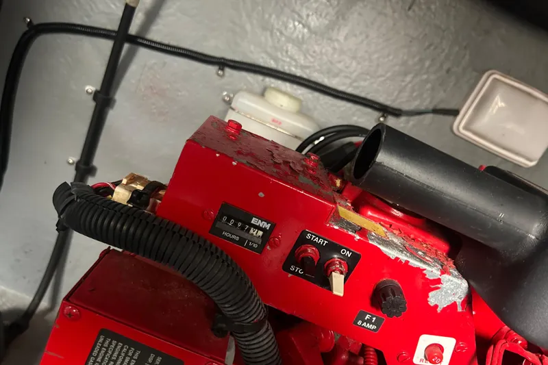 Slide: The Image of Engine compartment of a 2001 Sea Ray 380 Sundancer with red machinery and control switches. - 23