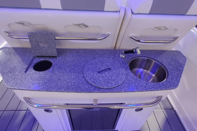 Slide: The Image of 2023 Chaparral 300 OSX boat kitchenette with granite countertop and stainless steel sink. - 11