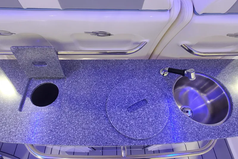 Slide: The Image of 2023 Chaparral 300 OSX boat kitchen with granite countertop and stainless steel sink. - 12