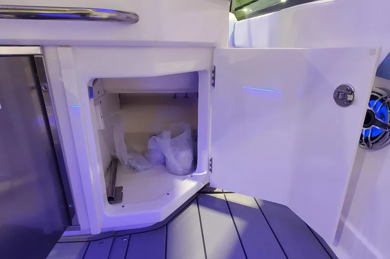 Slide: The Image of Open storage compartment on 2023 Chaparral 300 OSX boat with sleek interior design. - 15