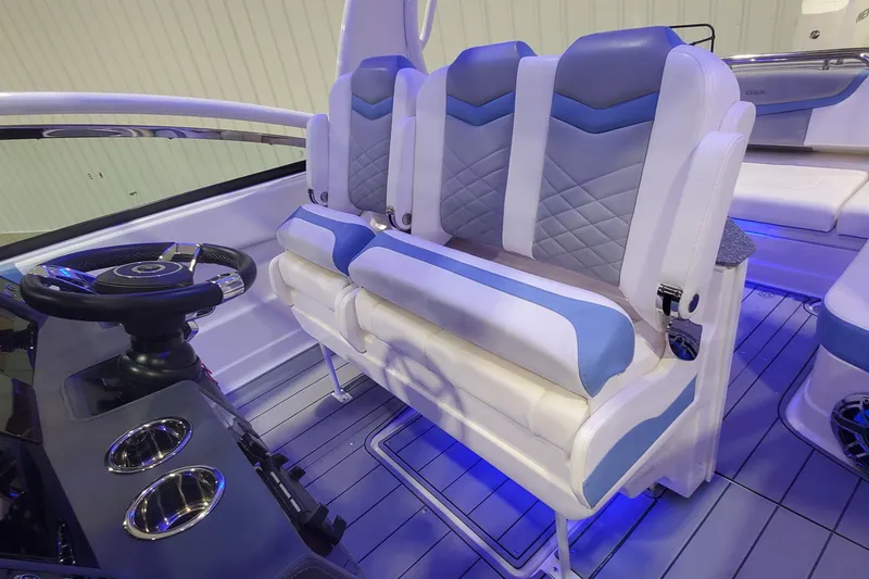 Slide: The Image of 2023 Chaparral 300 OSX boat interior with blue and white seating and steering wheel. - 16