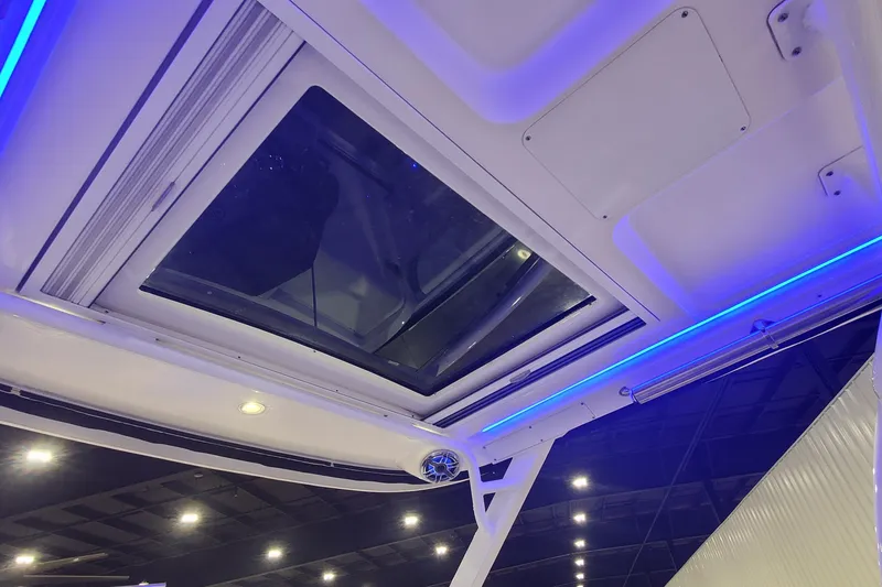 Slide: The Image of 2023 Chaparral 300 OSX boat interior with blue LED lighting and skylight. - 17