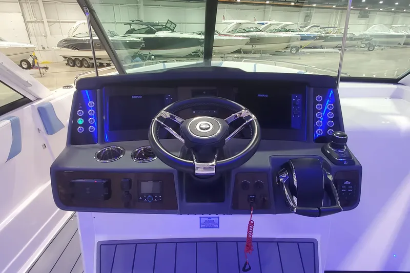 Slide: The Image of 2023 Chaparral 300 OSX boat dashboard with steering wheel and control panel. - 21