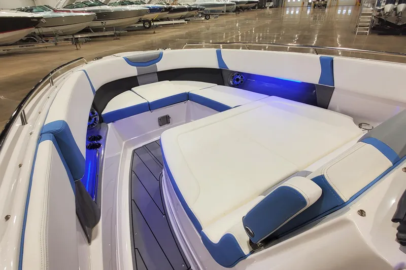 Slide: The Image of 2023 Chaparral 300 OSX boat interior with blue LED lighting and cushioned seating. - 24