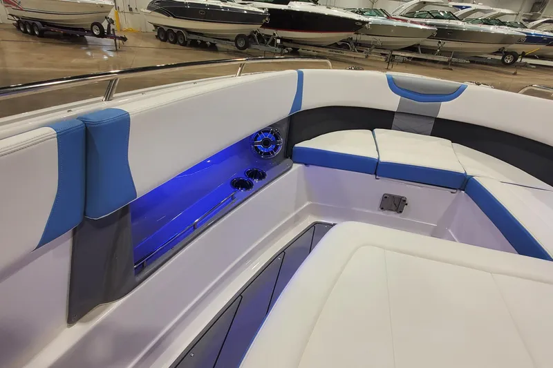 Slide: The Image of 2023 Chaparral 300 OSX boat interior with blue LED lighting and cushioned seating. - 25