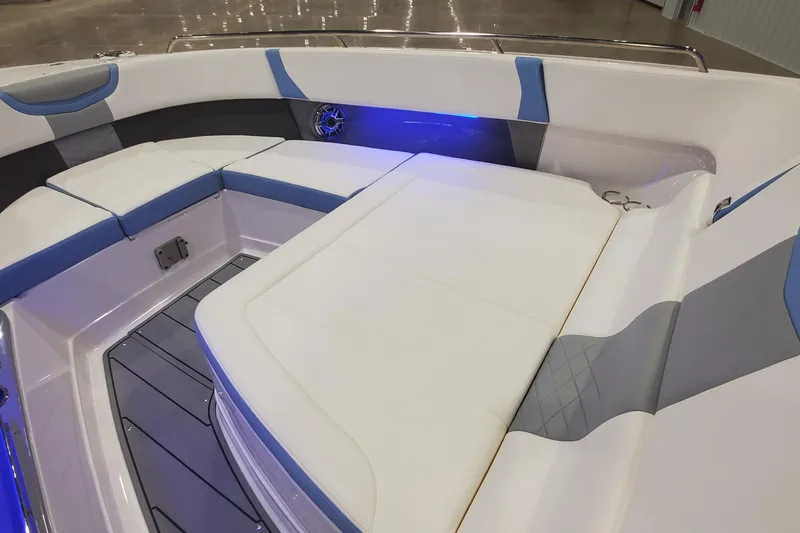 Slide: The Image of 2023 Chaparral 300 OSX boat interior with blue LED lighting and cushioned seating. - 26