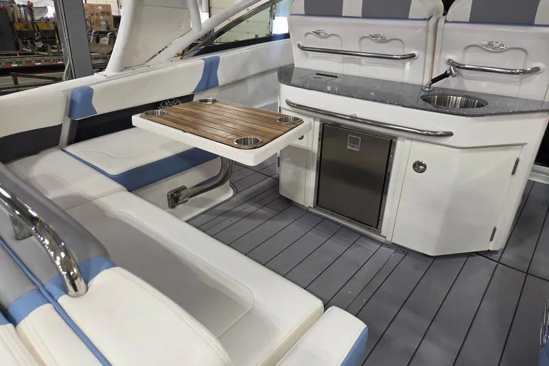 Slide: The Image of 2023 Chaparral 300 OSX boat interior with seating, table, and kitchenette. - 3