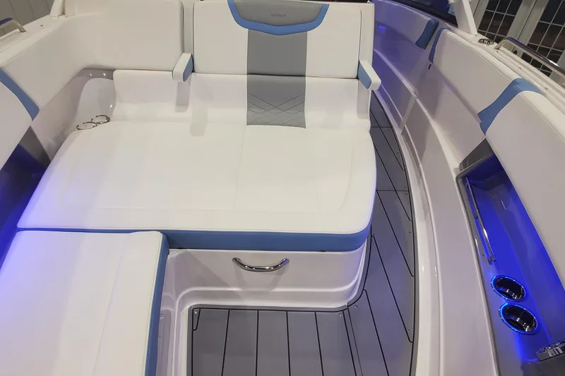 Slide: The Image of 2023 Chaparral 300 OSX boat interior with white and blue seating, illuminated cup holders. - 32