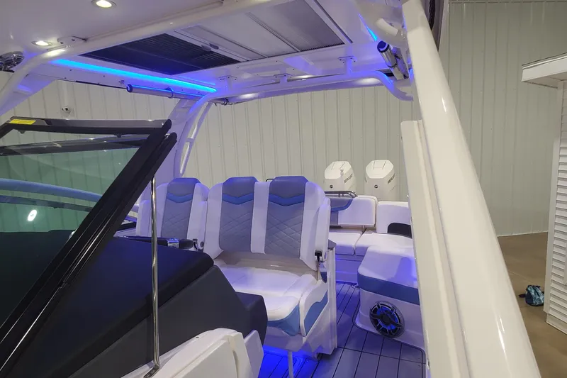 Slide: The Image of 2023 Chaparral 300 OSX boat interior with modern seating and ambient blue lighting. - 33