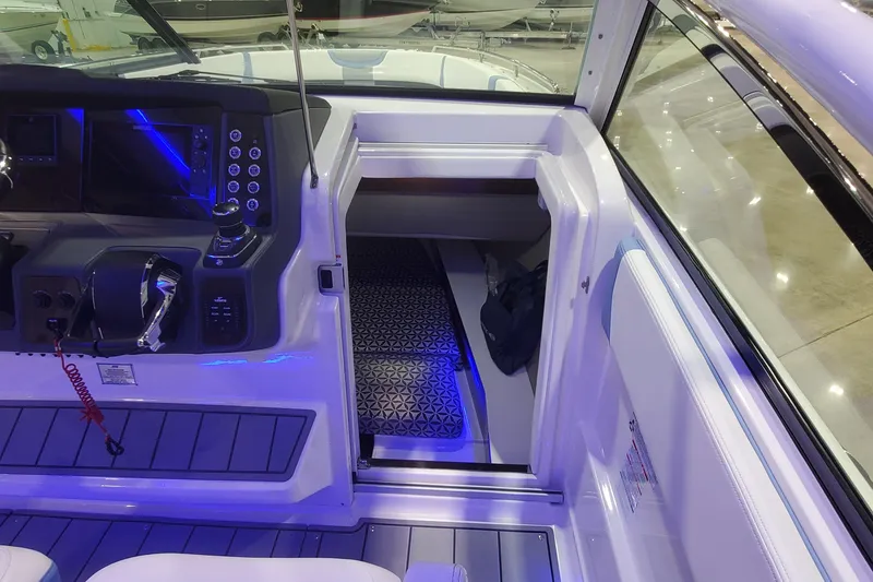 Slide: The Image of 2023 Chaparral 300 OSX boat interior with illuminated cockpit and cabin entrance. - 40