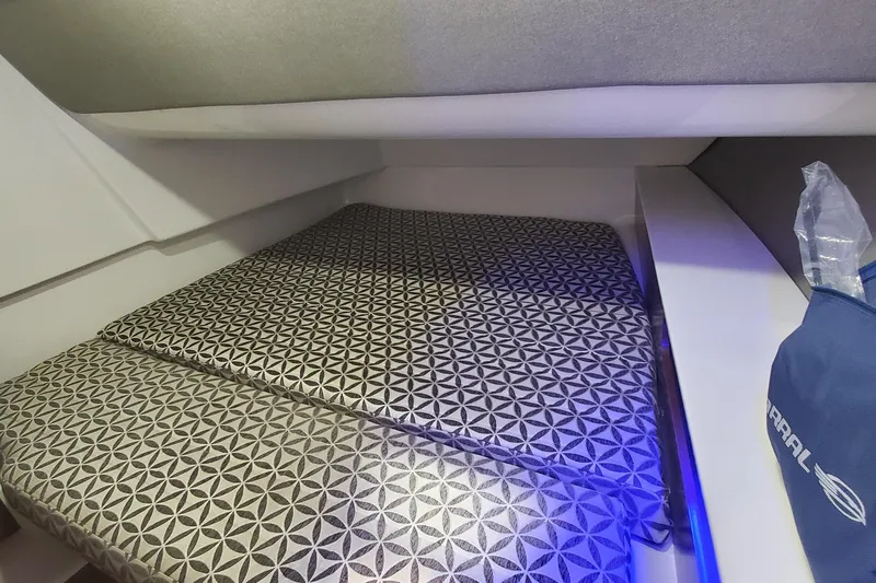 Slide: The Image of 2023 Chaparral 300 OSX cabin interior with patterned bedding and modern design. - 43