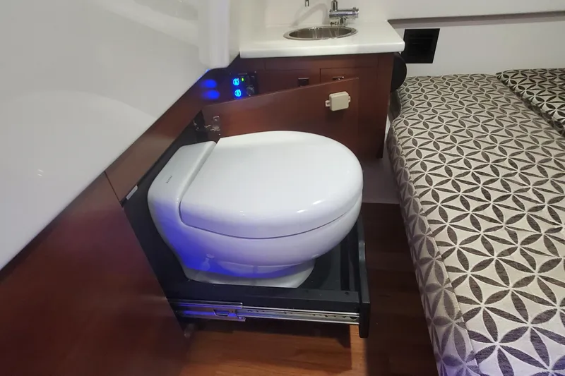 Slide: The Image of 2023 Chaparral 300 OSX interior with compact toilet and sink setup. - 45