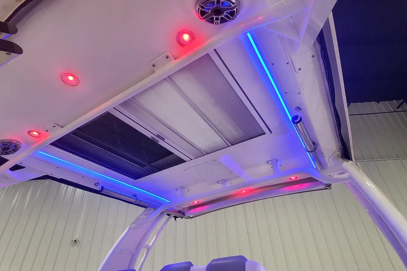 Slide: The Image of 2023 Chaparral 300 OSX boat interior with vibrant red and blue LED lighting. - 48