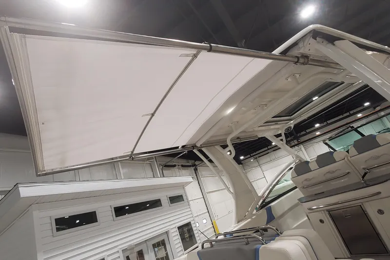 Slide: The Image of 2023 Chaparral 300 OSX boat with extended canopy and seating area in showroom. - 5