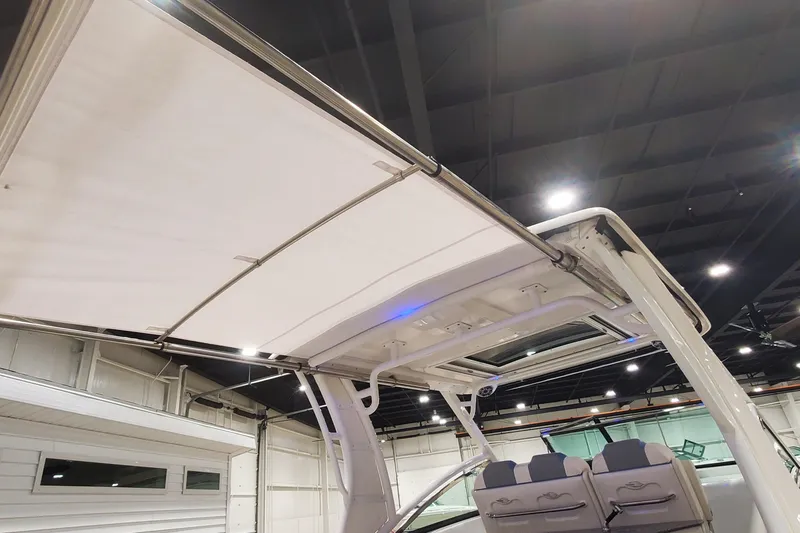 Slide: The Image of 2023 Chaparral 300 OSX boat with retractable canopy in showroom. - 6