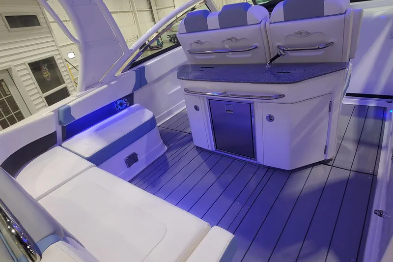 Slide: The Image of 2023 Chaparral 300 OSX boat interior with seating, kitchenette, and ambient lighting. - 8