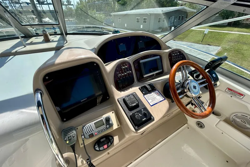 Slide: The Image of 2005 Sea Ray Sundancer 320 helm with navigation equipment and wooden steering wheel. - 14