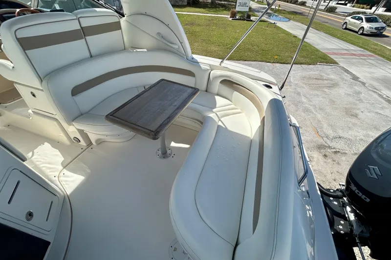 Slide: The Image of 2005 Sea Ray Sundancer 320 boat interior with white seating and wooden table. - 17