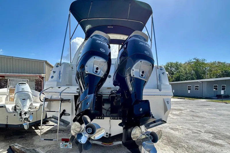 Slide: The Image of 2005 Sea Ray Sundancer 320 with dual outboard engines, parked outdoors. - 6