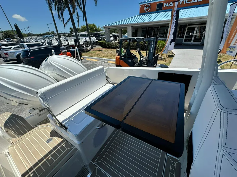 Slide: The Image of 2024 Windy SR28 CC boat with seating and table, docked at a marina. - 18