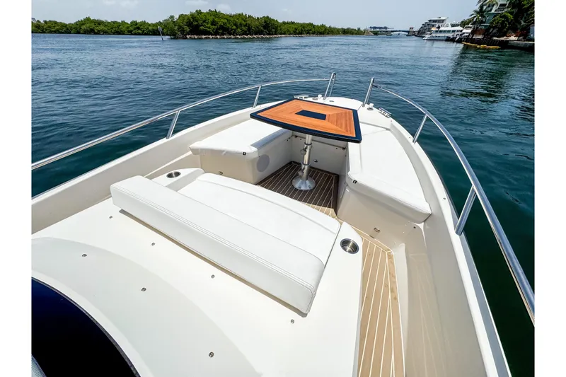 Slide: The Image of The image shows the foredeck of a 2024 Windy SR28 CC boat with a wooden table. - 13