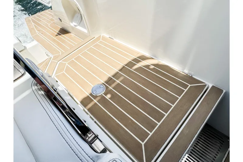 Slide: The Image of The image shows the deck of a 2024 Windy SR28 CC boat with wood-like finish and white lines. - 20