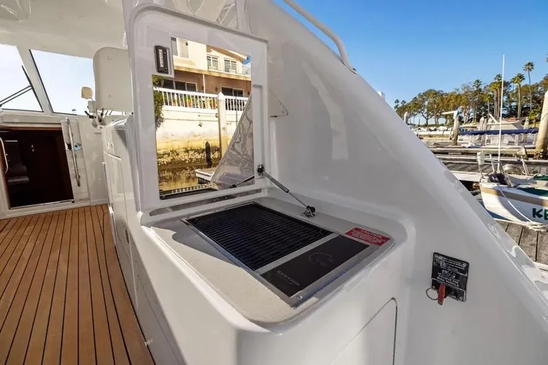 Slide: The Image of 2012 Cabo 44 Hardtop Express yacht with outdoor grill and teak flooring. - 14
