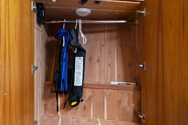 Slide: The Image of Wooden closet with life jackets inside a 2012 Cabo 44 Hardtop Express boat. - 18