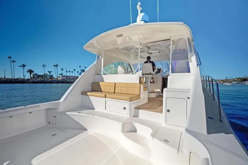 Slide: The Image of 2012 Cabo 44 Hardtop Express yacht with spacious deck and seating, cruising on a sunny day. - 23