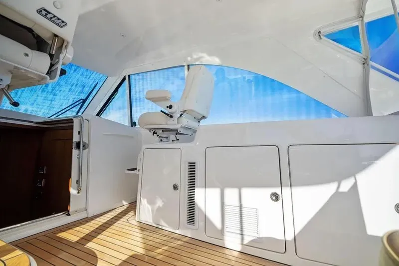 Slide: The Image of Interior of 2012 Cabo 44 Hardtop Express yacht with white seating and wooden flooring. - 25