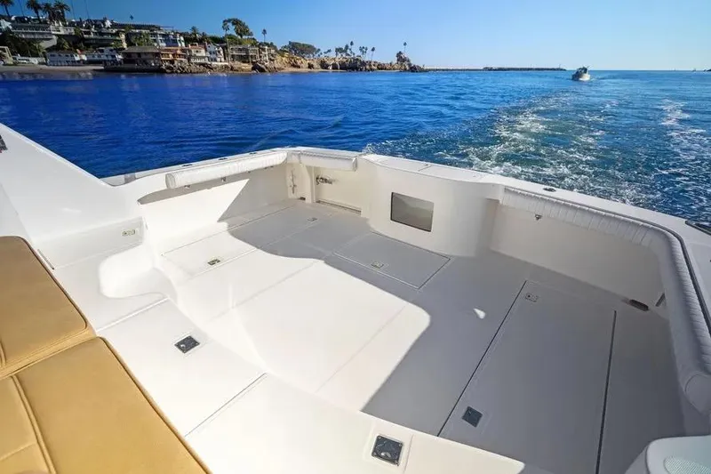 Slide: The Image of 2012 Cabo 44 Hardtop Express boat deck with ocean view and coastal background. - 28