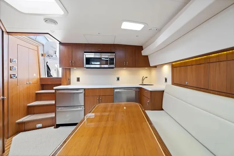 Slide: The Image of Luxurious interior of 2012 Cabo 44 Hardtop Express yacht with modern kitchen and seating area. - 4