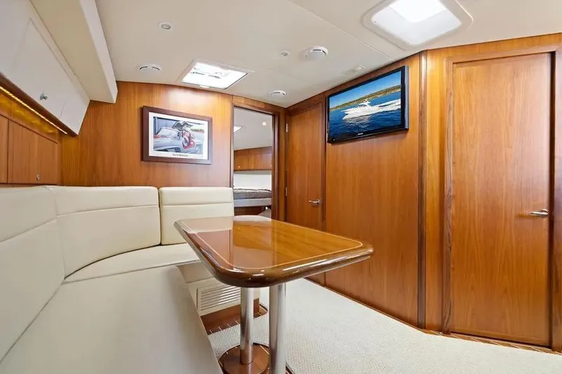 Slide: The Image of Luxurious interior of 2012 Cabo 44 Hardtop Express yacht with wood paneling and seating area. - 7