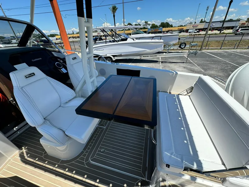 Slide: The Image of 2024 Windy SR28 CC boat interior with white seating and wooden table. - 19