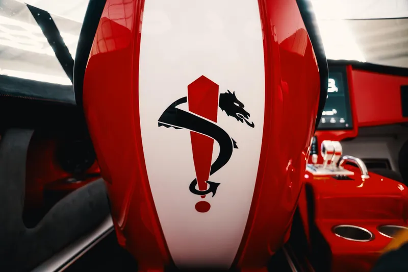 Slide: The Image of Red and white interior of 2025 Statement 360 CAT with dragon emblem. - 12