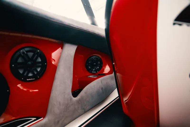 Slide: The Image of Interior of 2025 Statement 360 CAT boat with red and gray design, featuring speakers. - 13