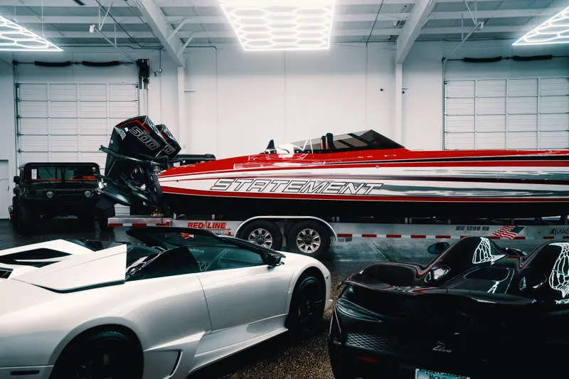Slide: The Image of Luxury cars and a Statement 360 CAT boat in a modern garage, 2025. - 19