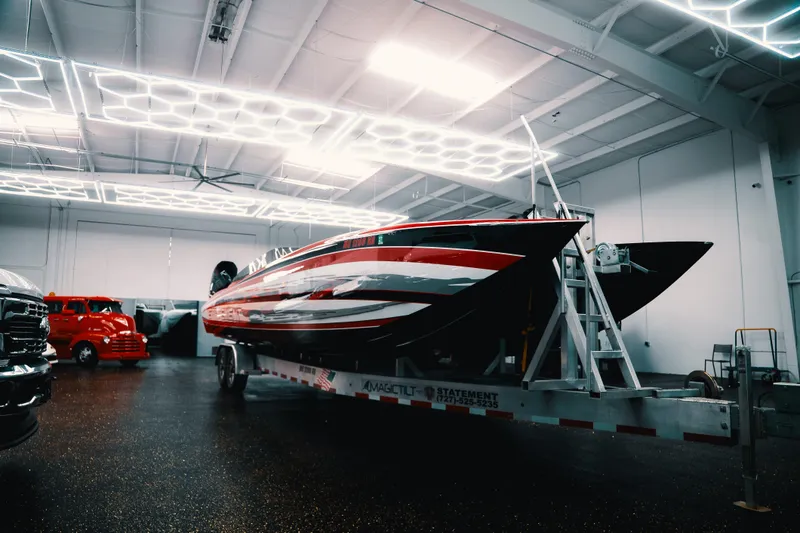 Slide: The Image of 2025 Statement 360 CAT boat in a modern showroom with geometric ceiling lights. - 2