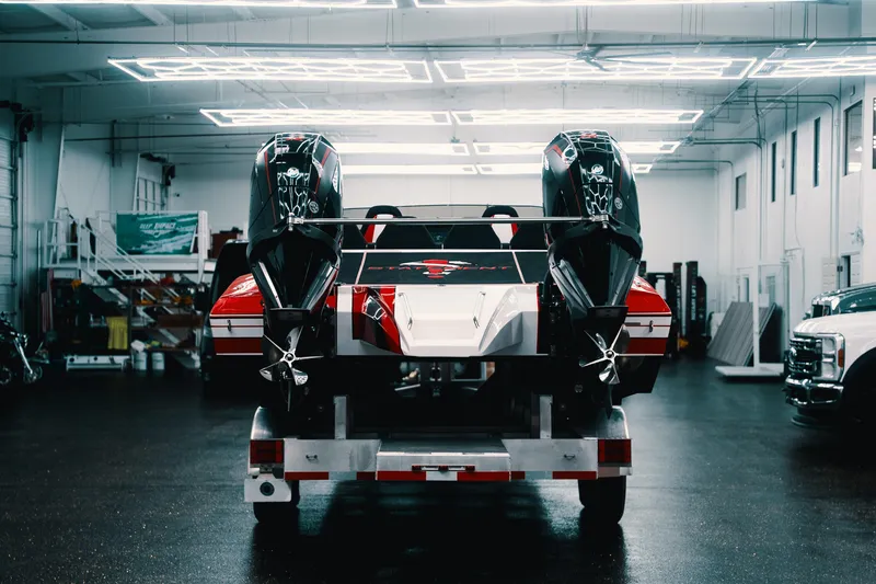 Slide: The Image of Red and white Statement 360 CAT boat with dual engines in a modern garage, 2025 model. - 24