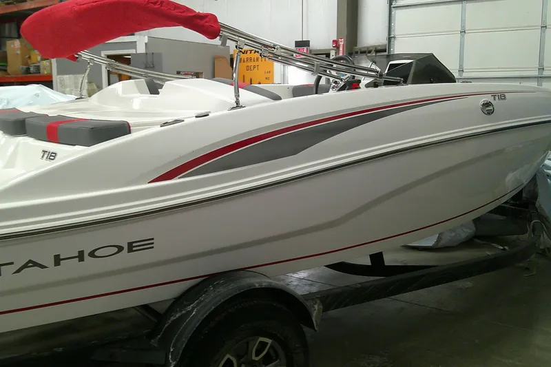 The Image of 2024 Tahoe T18 boat in a garage, featuring sleek white and red design. - 0
