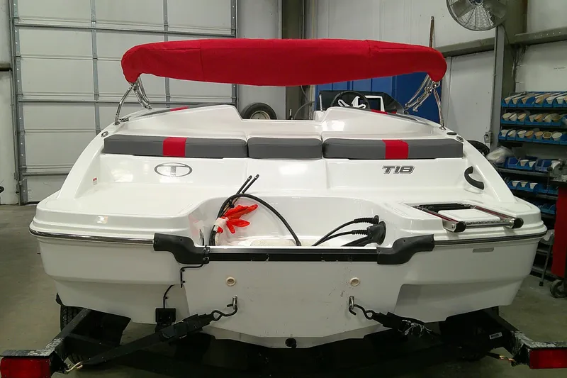 Slide: The Image of 2024 Tahoe T18 boat with red canopy in a garage setting. - 3