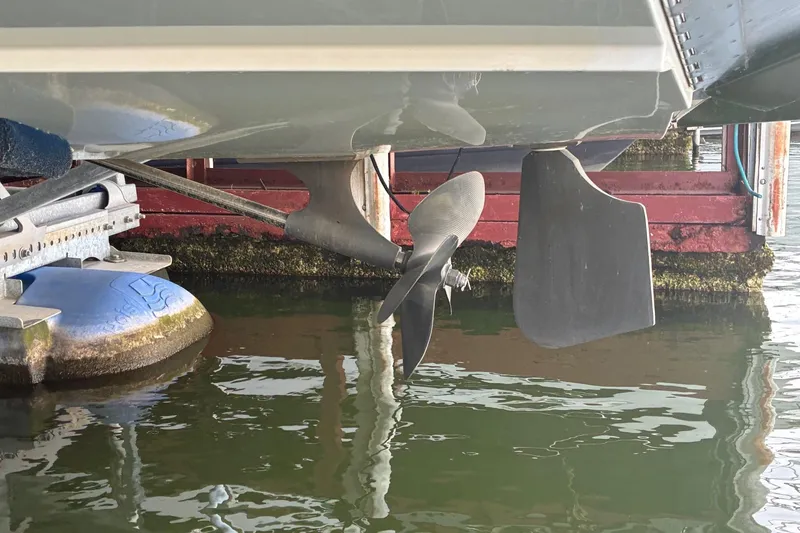 Slide: The Image of 2018 MasterCraft NXT22 boat propeller and rudder in water at dock. - 18