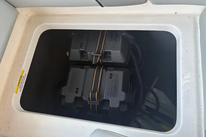 Slide: The Image of 2018 MasterCraft NXT22 boat battery compartment with dual batteries secured in place. - 21