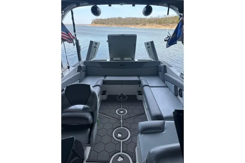 Slide: The Image of 2018 MasterCraft NXT22 boat interior with gray seating and lake view. - 3