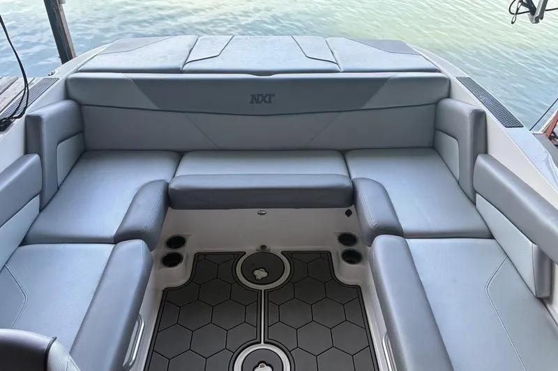 Slide: The Image of 2018 MasterCraft NXT22 boat interior with gray seating and hexagonal floor design. - 4