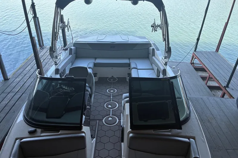 Slide: The Image of 2018 MasterCraft NXT22 boat interior with seating, docked by the water. - 5